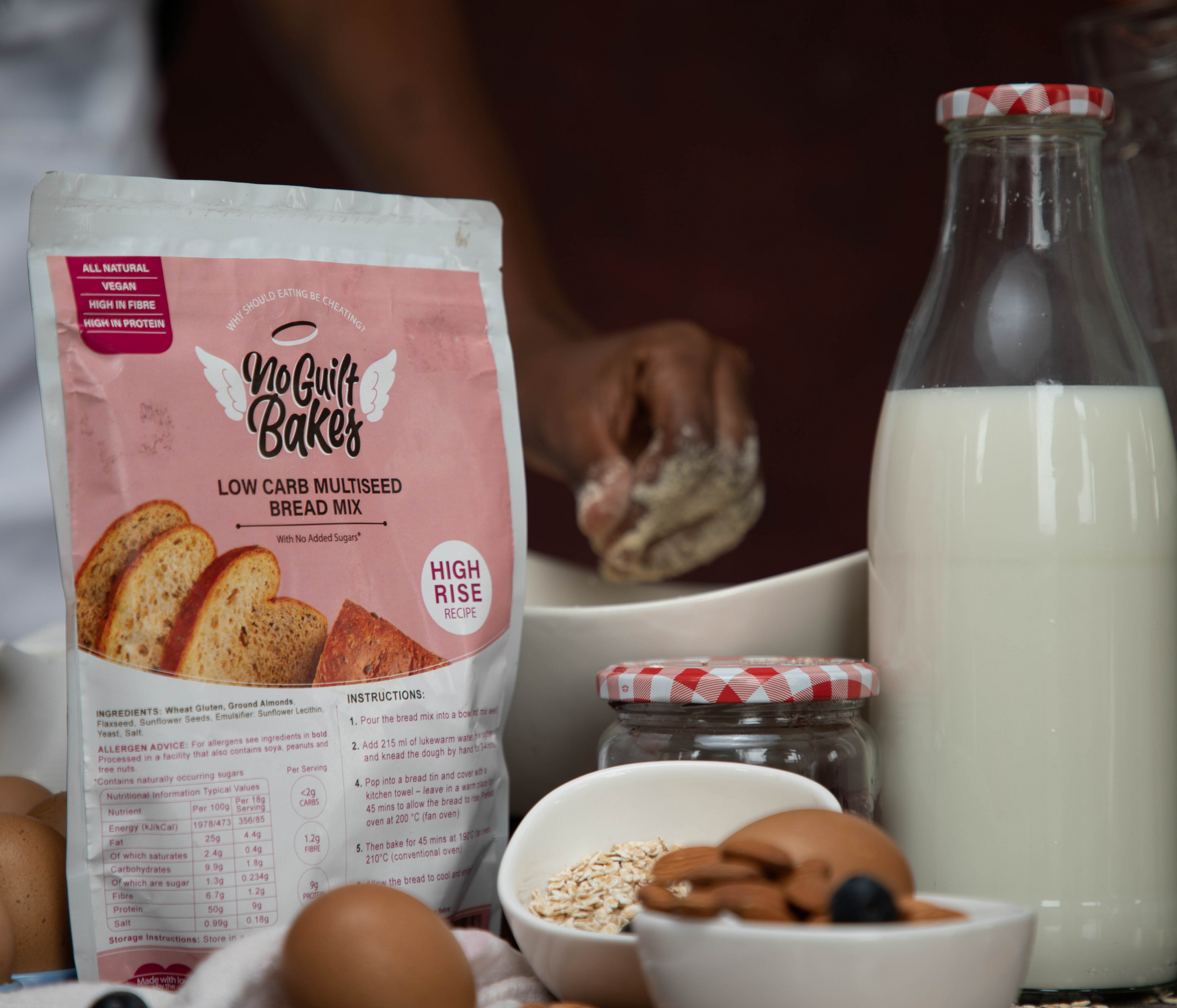 An image of bread being mixed in the background with the No Guilt Bakes bread mix in the foreground