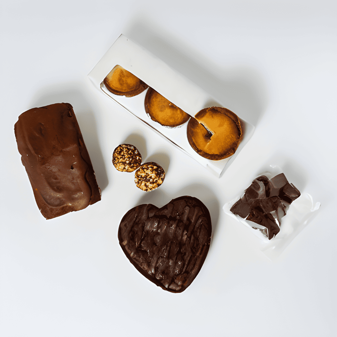 A Keto Share the Love Box of sugar-free treats and pastries on a white surface, perfect for a healthy lifestyle by No Guilt Bakes.