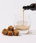 A glass of low-sugar Keto Fudge - Irish Cream Flavour from No Guilt Bakes is being poured into a glass.