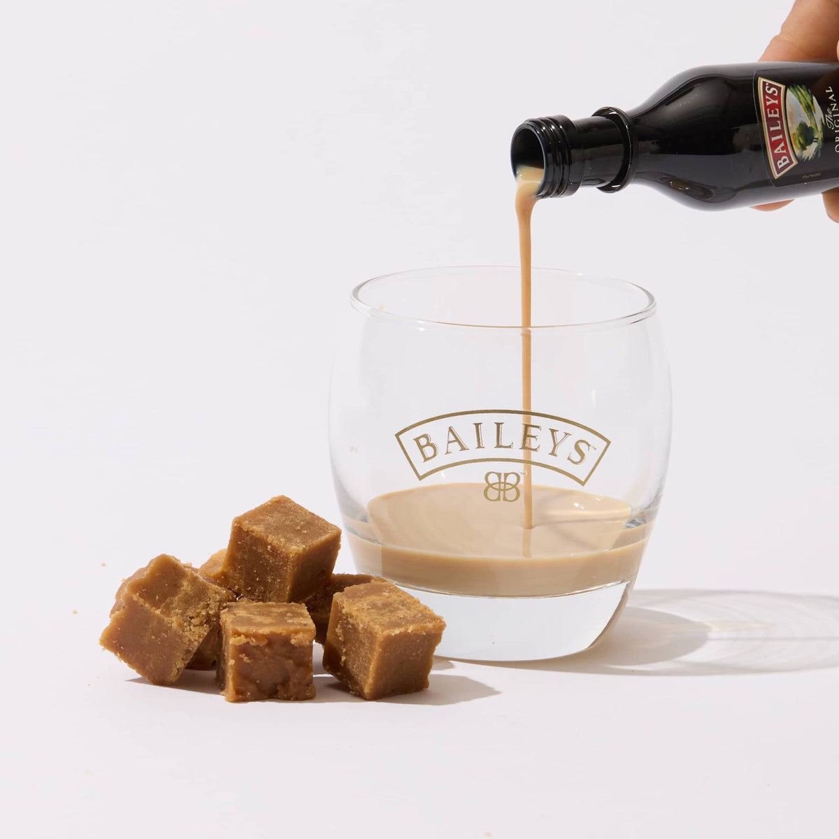 A glass of low-sugar Keto Fudge - Irish Cream Flavour from No Guilt Bakes is being poured into a glass.